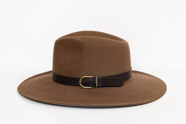 Cappello classico in feltro marrone cowboy con cinturino e chiusura in rame su sfondo bianco Immagine Stock