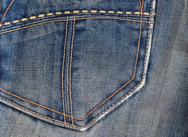 Worn denim blue fabric on back pocket of vintage jeans — Stock Photo, Image