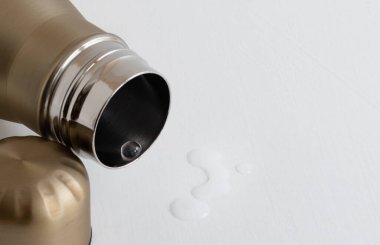 Beyaz arka planda metal termosta şeffaf temiz su damlası