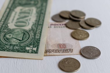 Bir dolar banknot ve yüz ruble banknot. Arka planda bulanık paralar var.