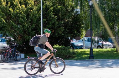 Man riding a bicycle along the pedestrian part of the street. Ukraine, Zhitomir, July 21, 2022