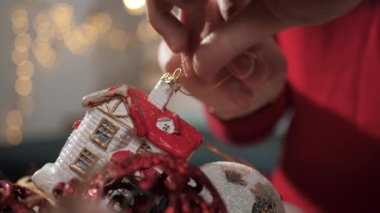 Noel ağacı süslüyorum. Kadın eli oyuncaklı Noel oyuncaklarını kutudan alır. Yakın çekim ve yavaş çekim