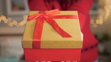 Noel hediyesi. Güzel paketlenmiş hediye kutusu kadınların elinde. Yakın çekim ve yavaş çekim