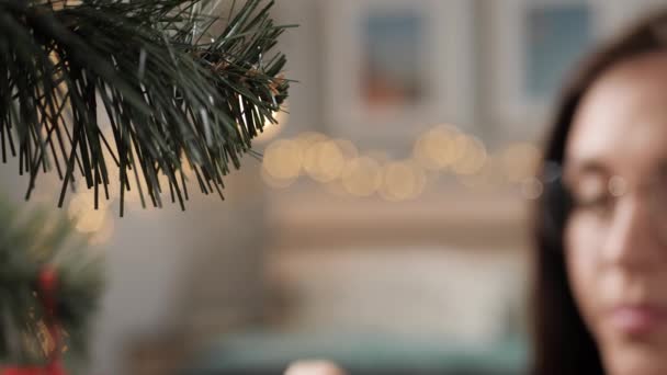 Menghias pohon Natal. Tangan wanita meletakkan mainan Natal di cabang pohon Natal. Close-up dan gerak lambat — Stok Video