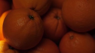 Orange fruit. Beam of sunlight passes over oranges in shade. Close-up