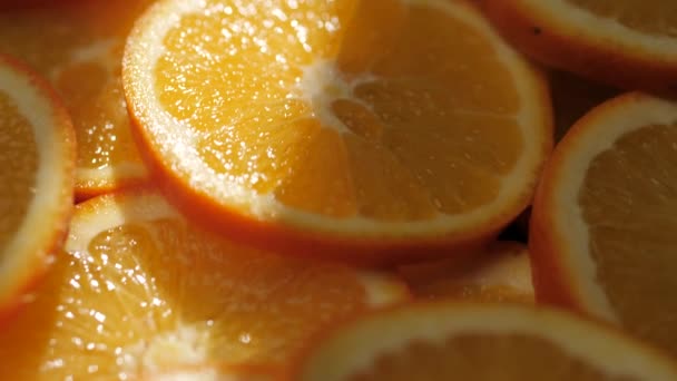 Fruta naranja. Macro toma de cámara se mueve lentamente mostrando rodajas de naranjas jugosas frescas en la sombra, naranjas brillan bellamente por el rayo de sol — Vídeos de Stock