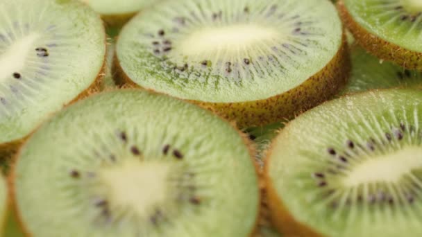 Kiwi fruit. Camera slowly pans down to show macro shot of fresh juicy sliced kiwi fruit — Vídeo de Stock