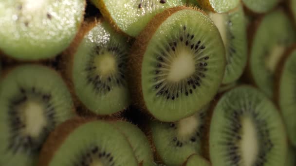 Des kiwis. Le rayon de tir vertical de la lumière du soleil passe sur des kiwis tranchés à l'ombre. Gros plan — Video