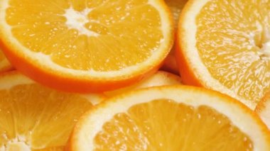 Portakal meyvesi. Kamera yavaşça aşağı iniyor ve taze, sulu, dilimlenmiş portakalların makro görüntüsünü gösteriyor.