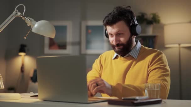 Hombre pulgar hacia arriba, de acuerdo emoción. Positivo sonriente barbudo hombre con auriculares en casa oficina mirando el ordenador webcam y muestra su pulgar hacia arriba — Vídeo de stock