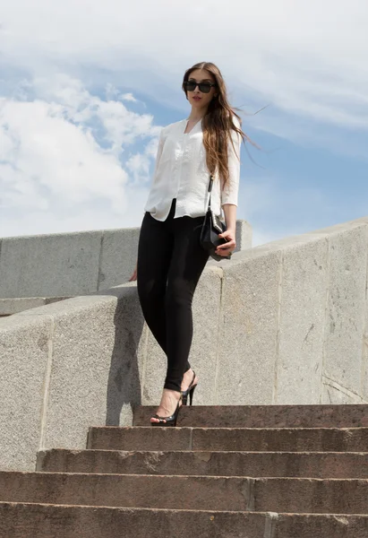 A woman is walking down the stairs — Stock Photo, Image