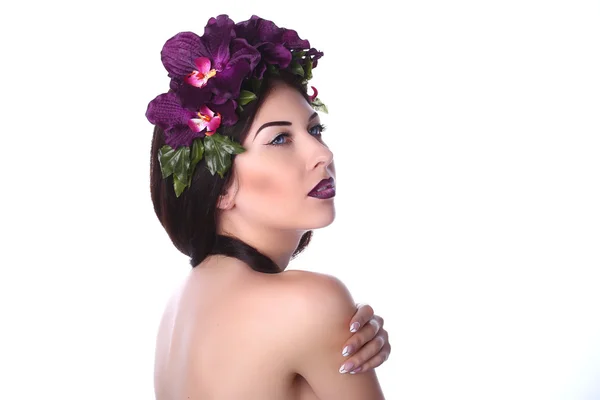 Sensual girl with makeup in a wreath of purple orchids — Stock Photo, Image