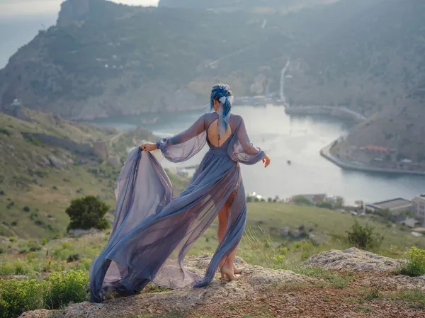 海の山を見て灰色のドレスで青い髪の若い美しい女性 自然の中で女性 ファッション写真 絹織物風になびく — ストック写真