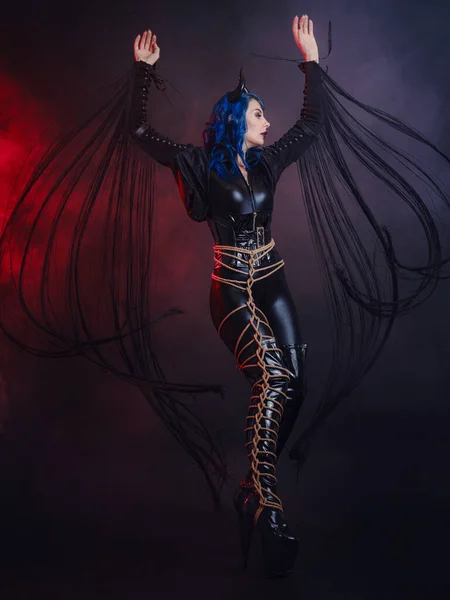 悪魔の完全な長さの写真 ハロウィンパーティーでは 黒い角とシバリとラテックススーツの面白いインプ ハロウィンメイク 悪魔の衣装だ 赤と青の煙地下の雰囲気 — ストック写真