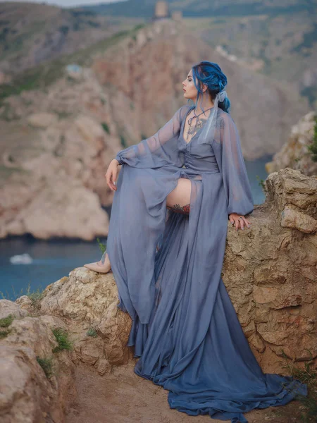 海の山を見て灰色のドレスで青い髪の若い美しい女性 自然の中で女性 ファッション写真 海ニンフ風が吹く — ストック写真