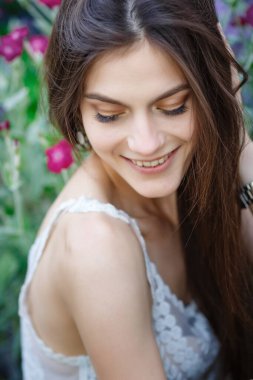 Yaz doğasında bahçeyle uğraşan güzel bir genç kadın. tapular ve bir yaz tuvaleti konsepti, yeşil bir bahçe ve özgürlük