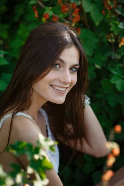 Yaz doğasında bahçeyle uğraşan güzel bir genç kadın. tapular ve bir yaz tuvaleti konsepti, yeşil bir bahçe ve özgürlük