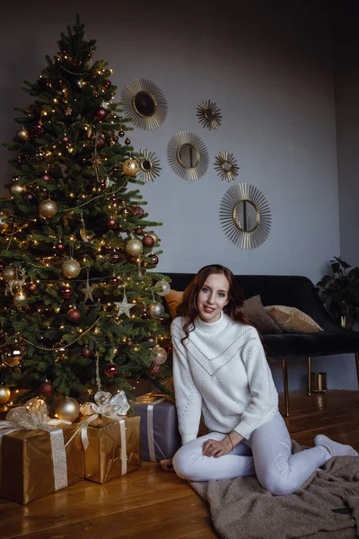 クリスマスの幸せな美しい女性 プレゼント付きのクリスマスツリーの近くの美容女性 新年のコンセプト 快適なホームコンセプト 柔らかい繊維の概念 — ストック写真