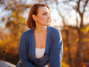 Sonbahar şehrinde yürüyen güzel bir genç kadının portresi. Sonbahar sezonunda parkta dinlenmek. Özgür doğal bayan sokakta derin nefes alıyor. Sıradan moda, zarif görünüş. Artı boyut modeli.