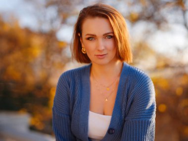 Sonbahar şehrinde yürüyen güzel bir genç kadının portresi. Sonbahar sezonunda parkta dinlenmek. Özgür doğal bayan sokakta derin nefes alıyor. Sıradan moda, zarif görünüş. Artı boyut modeli.