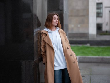 Güz bulutlu Moskova 'da Lenin Kütüphanesi' nde bej ceketli güzel bir kadın yürüyor. Sokak tarzı. Rusya 'ya Seyahat.