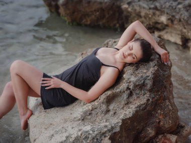 Hayat tarzı mayo, Rocky Beach 'te güzel bir kadının fotoğraf çekimi. Açık havada sağlıklı bir yaşam tarzı. Sakin ve sessiz yolculuk konsepti bir insanın mutluluğu ve özgürlüğü hissettiği an..