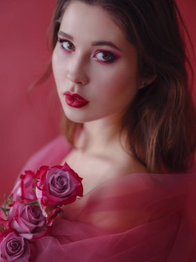 Güzel bir buket çiçekle çekici esmer Asyalı kadın. Parlak makyajlı güzel bir kadın. Güllü sanat portresi. Gençlik ve cilt bakımı kavramı