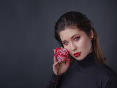 Kırmızı dudaklı, siyah balıkçı yakalı, koyu gri yakalı, baştan çıkarıcı Asyalı kadın. Güzellik ve sağlık kavramı.