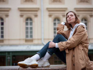 Güzel bej ceketli güzel bir kadın sonbahar bulutlu Moskova 'da yürüyor, Bolşoy Tiyatrosu' nun yanında yürüyor. Sokak tarzı. Rusya 'ya Seyahat.