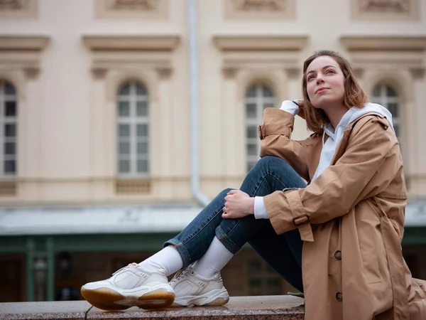 Güzel bej ceketli güzel bir kadın sonbahar bulutlu Moskova 'da yürüyor, Bolşoy Tiyatrosu' nun yanında yürüyor. Sokak tarzı. Rusya 'ya Seyahat.