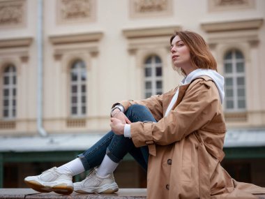 Güzel bej ceketli güzel bir kadın sonbahar bulutlu Moskova 'da yürüyor, Bolşoy Tiyatrosu' nun yanında yürüyor. Sokak tarzı. Rusya 'ya Seyahat.