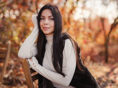 Beautiful young brunette spends her free time in the autumn forest. Embrace life, happiness, joyful habits, mindfulness, health and wellness, empowerment, autumn thinking
