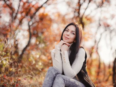 Beautiful young brunette spends her free time in the autumn forest. Embrace life, happiness, joyful habits, mindfulness, health and wellness, empowerment, autumn thinking