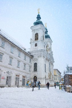 Graz, Avusturya - 09 Aralık 2021: Graz, Steiermark, Avusturya 'da güzel Mariahilfer kilisesinin önündeki insanlar