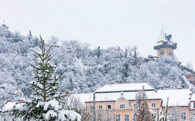 Yoğun kar yağışı ve Avusturya 'nın Graz, Steiermark bölgesindeki Schlossberg tepesindeki ünlü saat kulesi. Seçici odak
