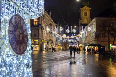 Graz, Avusturya-02 Aralık 2021: Avusturya 'nın Steiermark kentindeki Herrengasse caddesindeki ünlü Saat Kulesi ile güzel Noel süslemeleri. Seçici odak