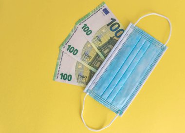 Tıbbi maskeler ve Avrupa para birimi banknotları. Coronavirüs kayıpları nedeniyle mali kriz, seçici odaklanma