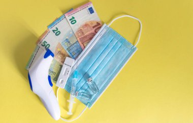 Para (Euro para birimi banknotları) tıbbi maskeler, antijen testi, aşı şişeleri ve şırınga ile. Coronavirüs kayıpları nedeniyle mali kriz, seçici odaklanma