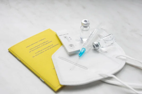 コロナウイルスCovid 19パンデミックの予防と治療に使用される医療用マスク 抗原検査 ワクチン証明書 ワクチンボトルと注射器 — ストック写真