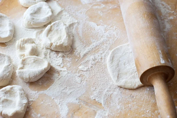 Dumpling dough and rolling pin on the board — Stock Photo, Image