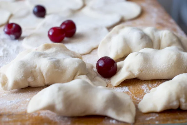 Raw dumplings with cherries and dough — Stock Photo, Image