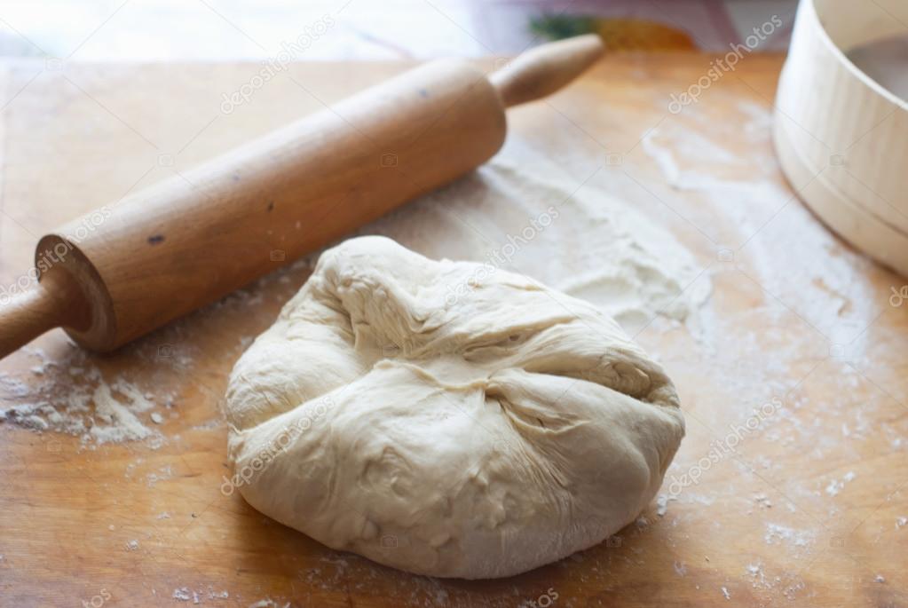 Ball of raw dough on a cutting board in the