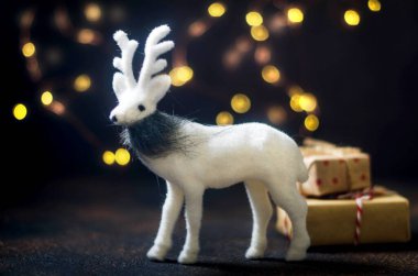 Sihirli geyikli Noel kartı, beyaz süslemeler ve karanlık kış tatili kartında çelenk ışıkları. Noel tatili kavramı. 