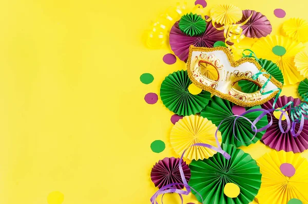Renkli kağıt konfetileri, karnaval maskesi ve sarı arka planda fotokopi alanı, tebrik kartı ve karnaval ya da doğum günü için parti davetiye şablonu tasarımı, Mardi Gras,