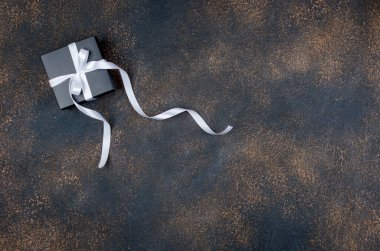 Siyah hediye kutuları ve koyu arkaplanda beyaz kurdeleyle süslenmiş, bayram tebrik kartı, kış etkinliği anlayışı, fotokopi uzayı ile şablon modelleme tebrik kartı,