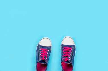 Açık mavi arka plan manzaralı eski bir çift mavi spor ayakkabı ve metin için yer var. Yaşam tarzı spor ayakkabısı..