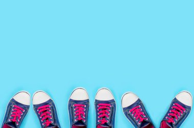 Açık mavi arka plan görünümlü ve metin için yeri olan bir sürü eski mavi spor ayakkabı. Yaşam tarzı spor ayakkabısı..