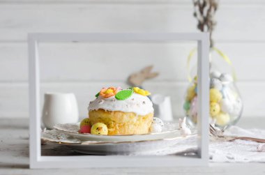 Paskalya için parlak arka planda, renkli süslemeli Paskalya pastası, dekoratif yumurta tatlısı ve tatil süslemeleri ile yer ayarla