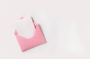 Beyaz arkaplan üzerine beyaz sayfa ve boş alan içeren pembe zarfı aç