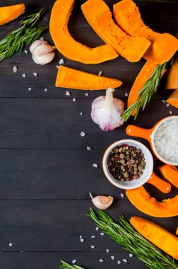 Eski karanlık masada biberiye, tuz ve baharatla pişirmek için balkabağı dilimleri. Sağlıklı yiyecekler gurmeler için. Seçici Odaklanma Sonbahar Ev Yemeği.